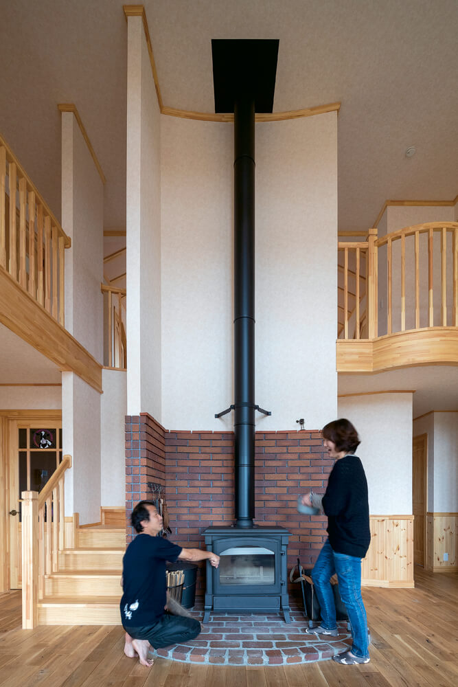 ご主人念願の薪ストーブがリビングの主役。長い煙突も空間デザインの大切な要素のひとつ