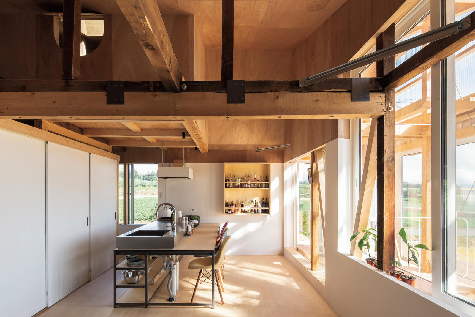 明るいダイニング・キッチンは構造現しで、屋根なりの高い天井が一層の開放感を与える