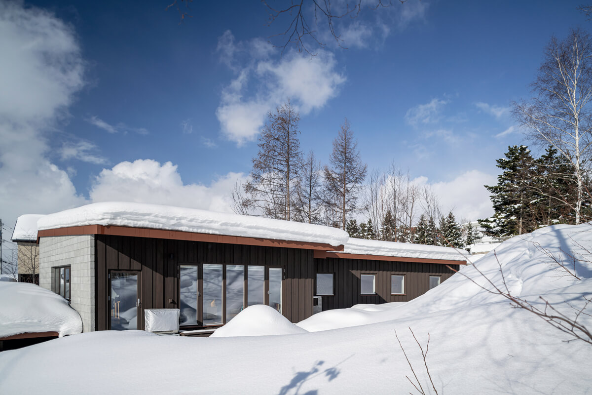 スイスの建築家であるマリオ・ボッタの建築が好きで、北海道の気候風土に根ざした家を建てたいと考えたNさんの願いをかたちにした、コンクリートブロック造の平屋。うず高く降り積もる雪の中にあって、力強い存在感を放つ