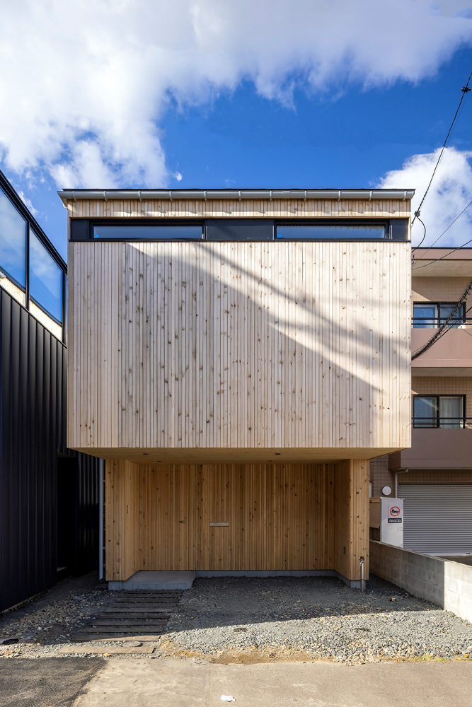 平地部分に住宅を建て2階をはね出させたYさん宅の外観。外壁は道南スギの板張り