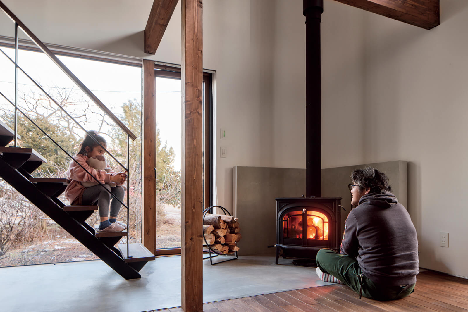 火のある暮らしに憧れて導入した薪ストーブは、調理も楽しめるモデル。テラス窓を介して薪の運び入れができるようになっていて、モルタル仕上げの土間と炉壁が、無垢材と調和しながら空間を引き締める