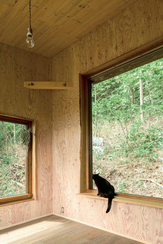 材本来の曲線や樹皮を意匠として生かして付けた窓枠も、建築家の手によるもの｡愛猫が座れるよう幅広にデザインされている