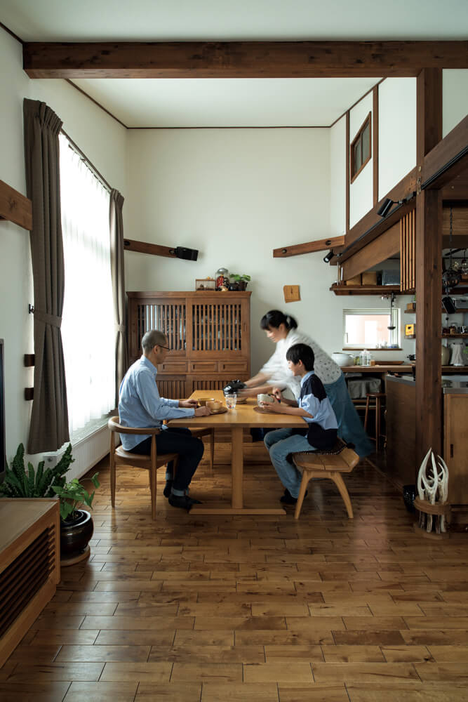 ダイニングの様子。奥にあるチェストはご夫妻がもともと所有されていたもので、この色に合わせて全体のカラーリングが設定された。南向きの窓は、太陽光をより多く採り入れられるように背が高くなっている