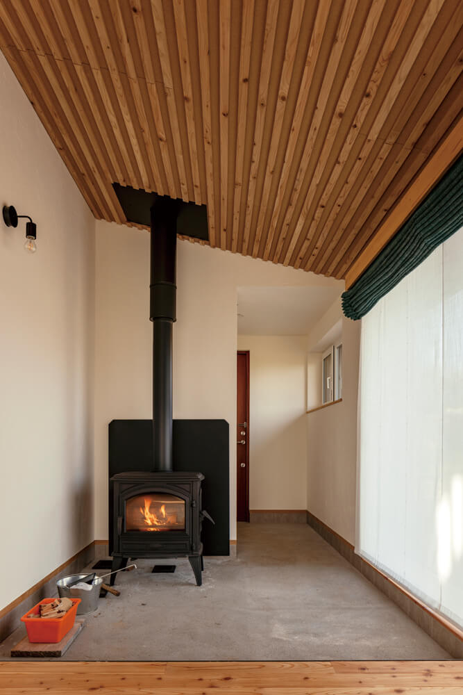 玄関からつながる土間スペースには、シンプルで力強い魅力を持つドブレの薪ストーブを設置。天井の勾配に沿って家全体を暖める