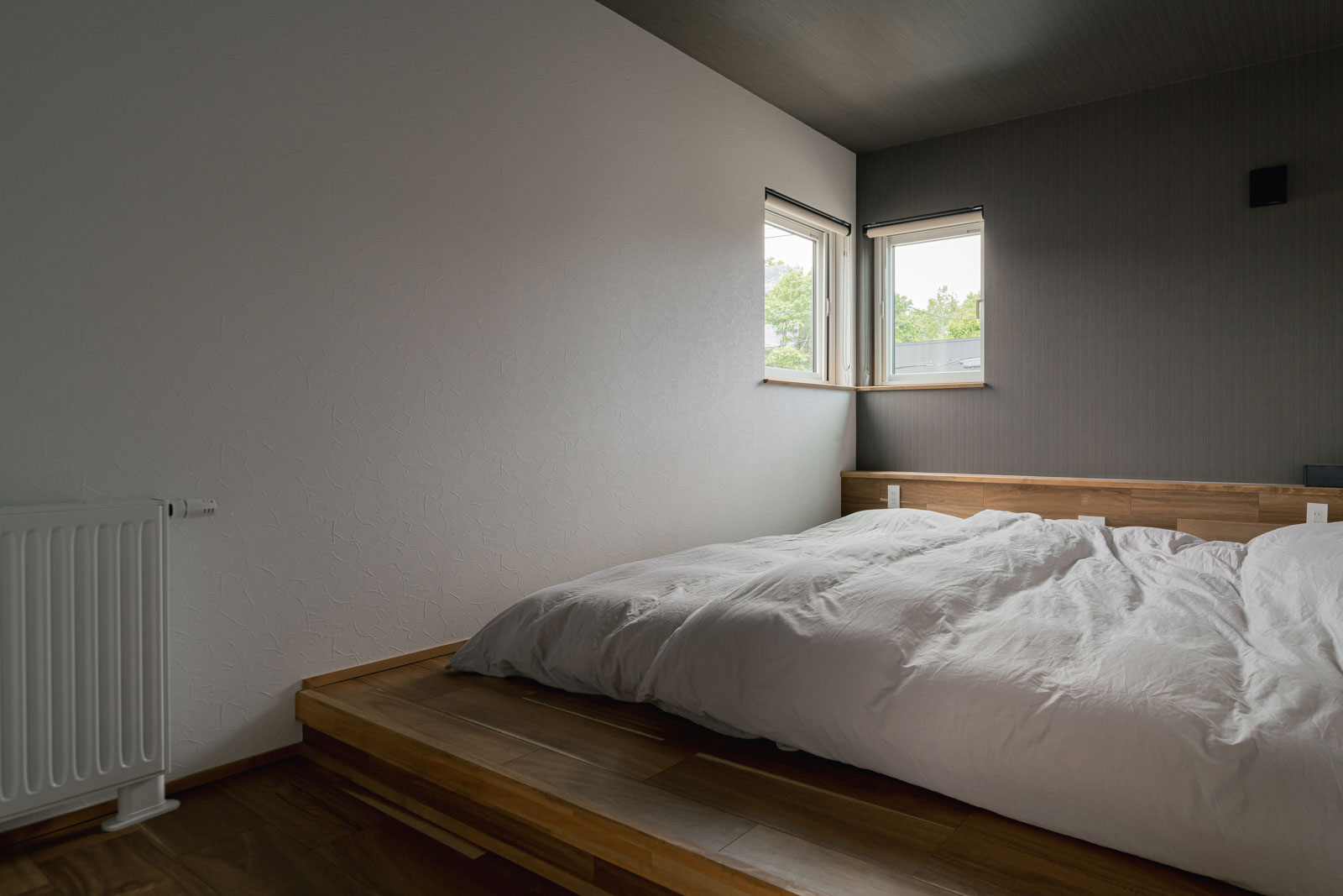 寝室のサイズにピッタリと合わせた小上がりにもなる造作のベッド