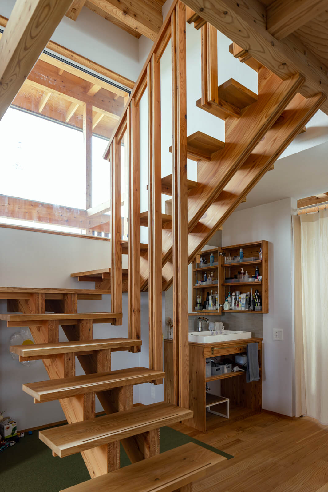 大工さんが一からつくり上げたカラマツパネルの木製階段。段板と桁が美しく端正に組み上げられているのが匠の技