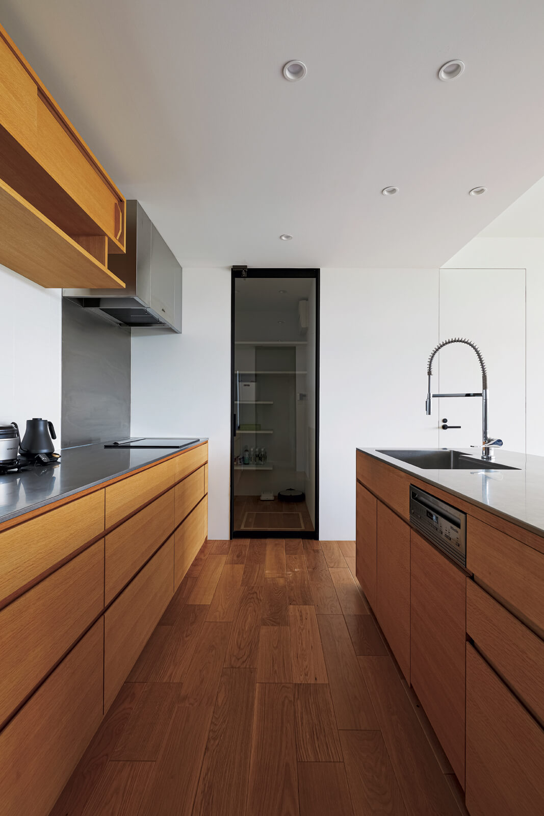 造作キッチンは機能的なセパレートタイプを採用。奥の扉はパントリーに通じる