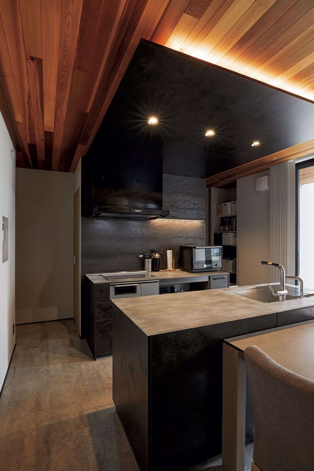 天井に黒のシートを貼り、スポットライトや間接照明でスタイリッシュな雰囲気を際立たせたキッチン