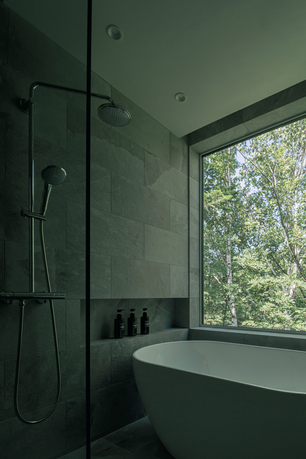 タイル張りの上質で大人な佇まいの「春」の浴室は、壁一面に景色を取り込む大きな窓を設えた。まるで露天風呂のような気分を味わえる