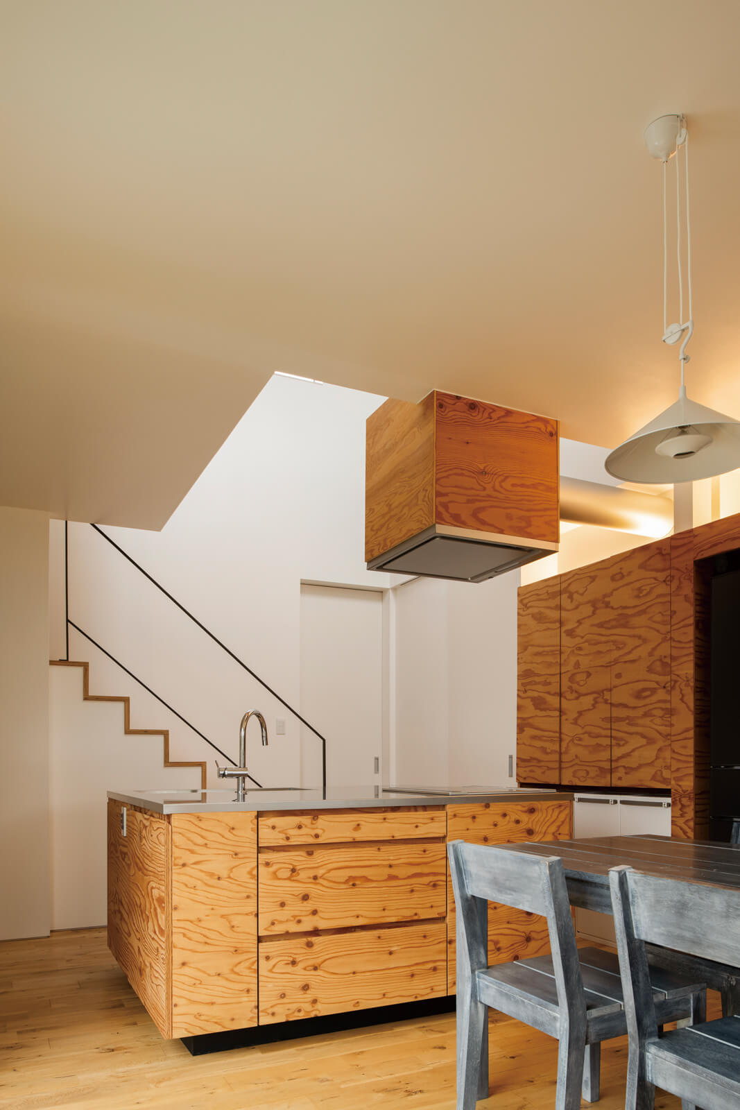 キッチンの面材は構造用合板、ワークトップにステンレスを採用。造作の棚はもちろんのこと、レンジフードも合板で覆い、統一感を演出。特徴的な木目や木の質感が目を惹く、シンプルかつ温かみのある佇まいのダイニング・キッチンとなった