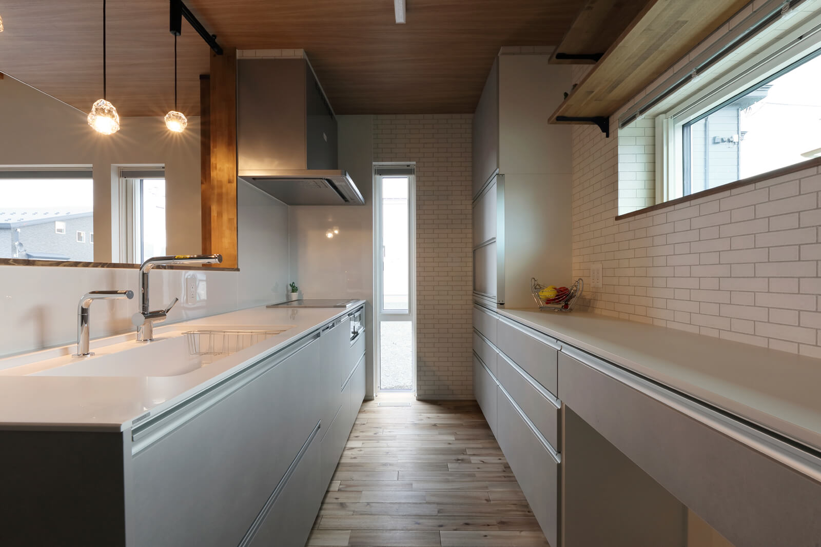 天井の木調クロスや壁のレンガ調クロスが上質感をもたらすキッチン