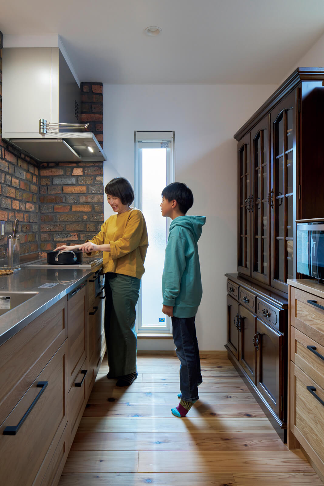 システムキッチンの面材はオーク。IHクッキングヒーターや食洗機の導入で家事の効率も上がり、フルタイムで働く奥さんの負担が少し減ったとか。何より子どもたちと同じ空間で作業できるようになったのが嬉しい変化だそう