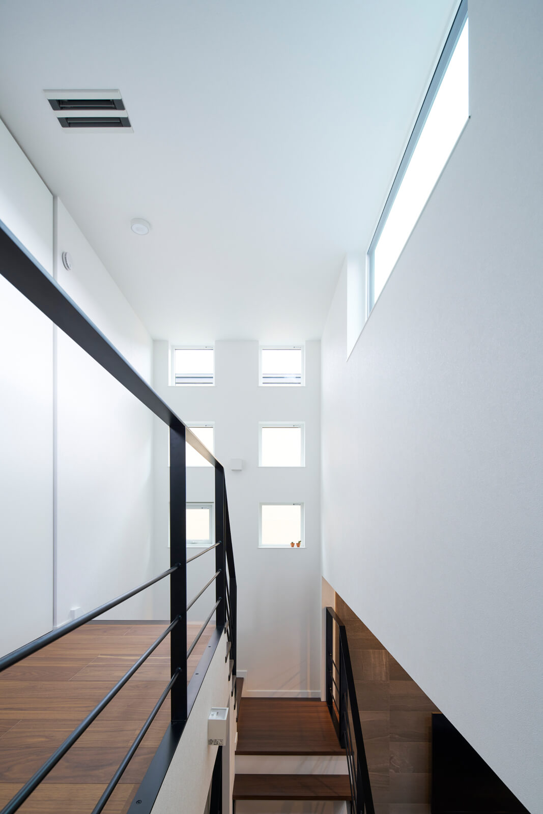2階の廊下はスリット窓から入る光で明るく、エアコンの吹き出し口で適温に保たれている。1階の床と2階の天井の温度差は2℃もないほど