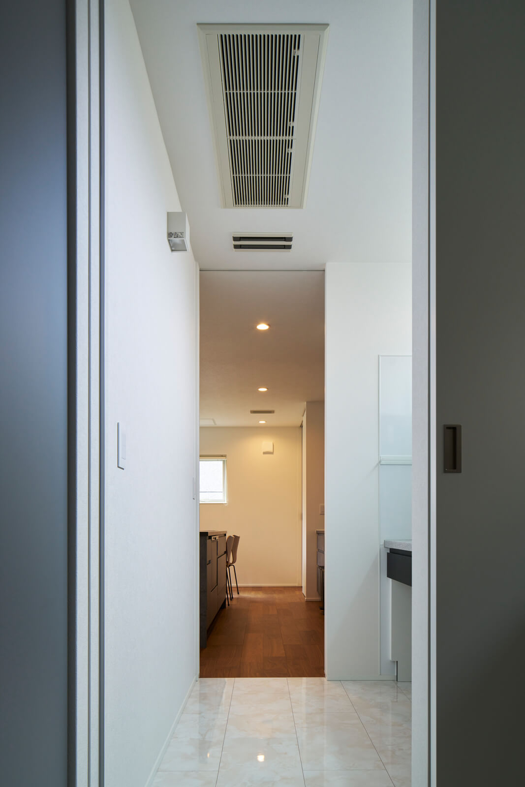 玄関の上に設置されたメインのエアコン。ダクトを通して家中に温風や冷風を効率よく届けるため、各部屋にエアコンを設置するより半分以下の消費電力で済むという