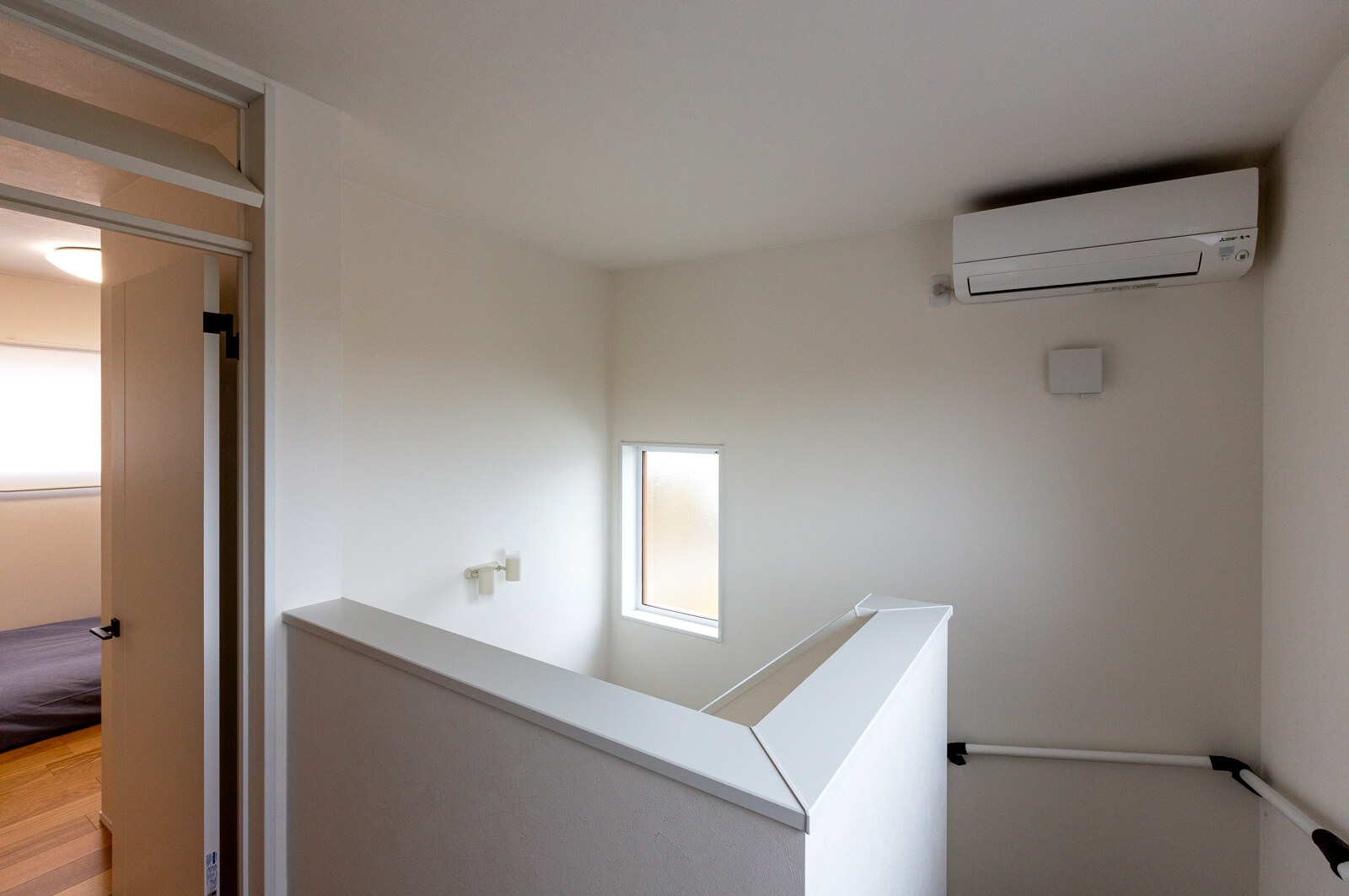 2階用の暖冷房エアコンは階段上に設置。寝室のドア上の開閉式欄間で暖気や冷気を取り込み、換気も効率アップしている