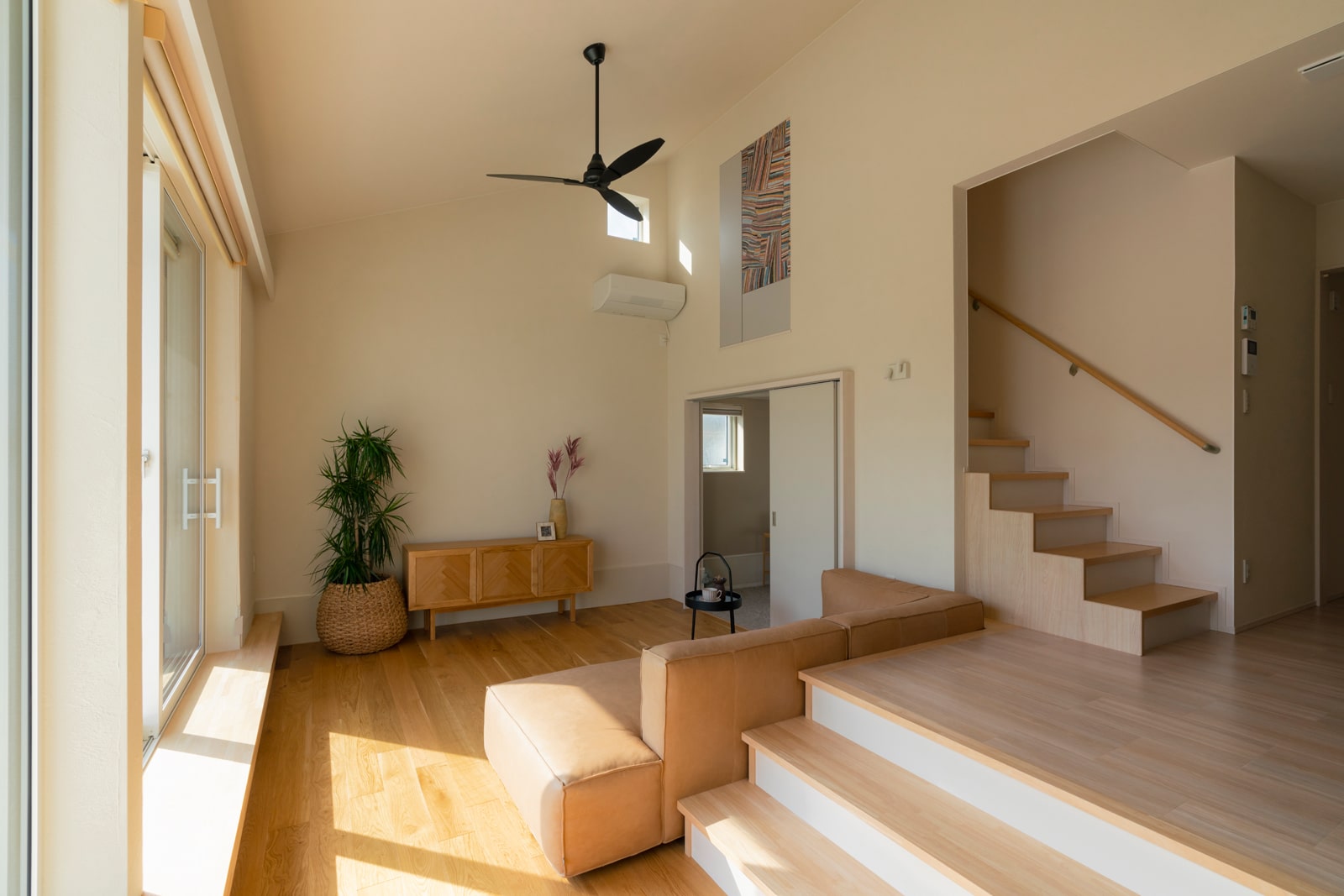 天井高4.5ｍの開放的なリビング空間。窓際のベンチ、床、ソファ、階段など、家族がそれぞれの好きな場所に座って過ごせるように設計