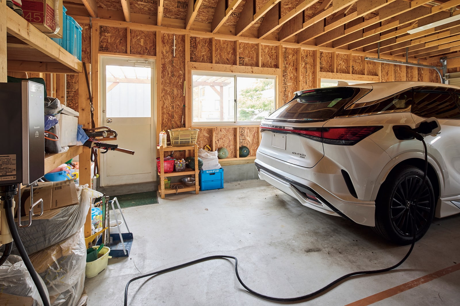 車庫内には、電気自動車の充電スタンドを設置。今後は車のバッテリーを活かして自家消費用の給電設備も備える予定。「これからの時代、環境に対する意識を高く持つことが大切。太陽光発電の積極的な活用で、カーボンニュートラルに貢献したいと考えています」とKさん