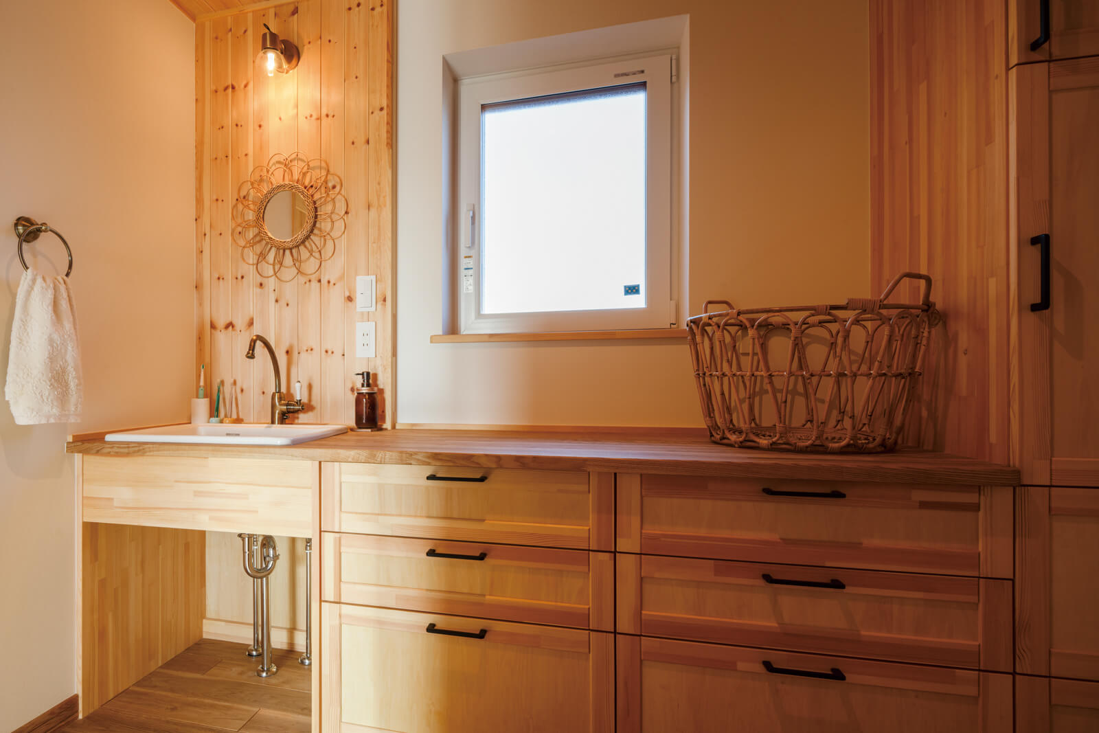 自然光で明るい洗面スペースは、ゆったりとした広さを確保。洗面台と収納を造作した