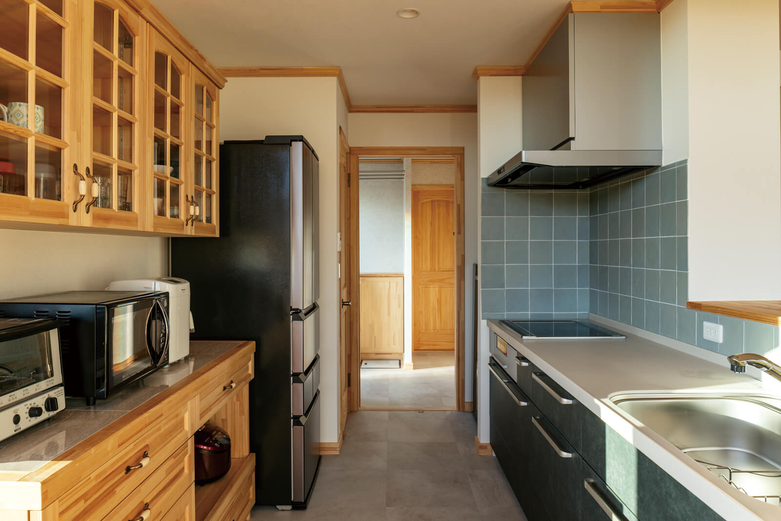 背面に容量たっぷりの収納を備えた使い勝手の良いキッチン。裏口、水まわりへも裏動線でアクセスでき、効率よく家事が行える