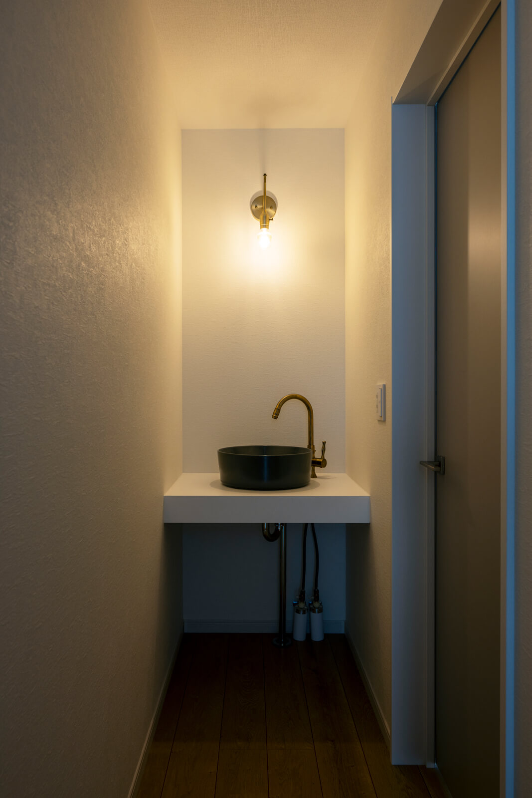 2階の階段ホールの一角には、洗面ボウルや照明、水栓金具など一つひとつを吟味して仕上げた造作洗面台がある