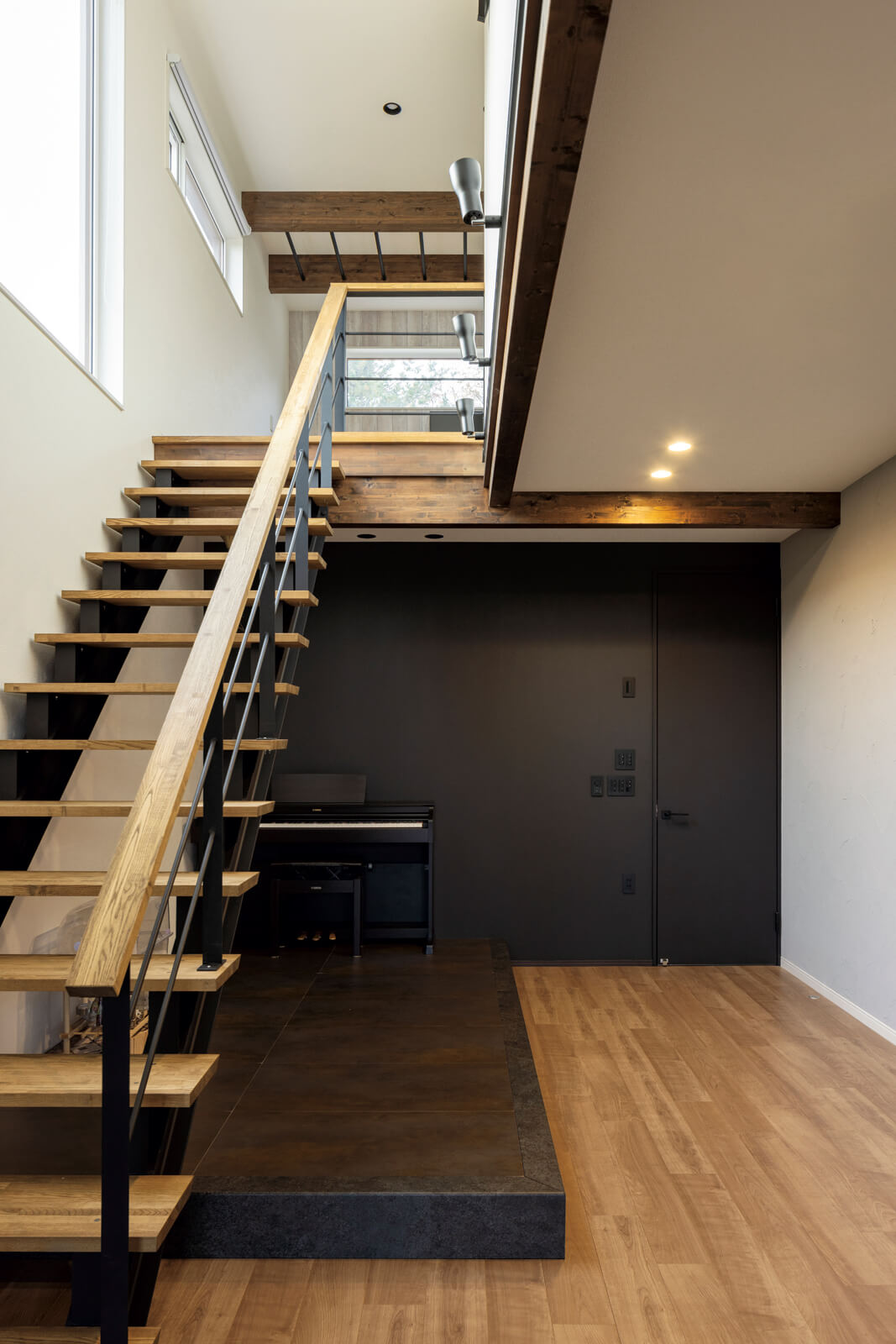 リビングのスケルトン階段にはアイアンを採用。階段下には、アイアンの質感、テイストに合わせた黒とさび色を効かせた小上がりを設け、開放的なLDK空間のアクセントに