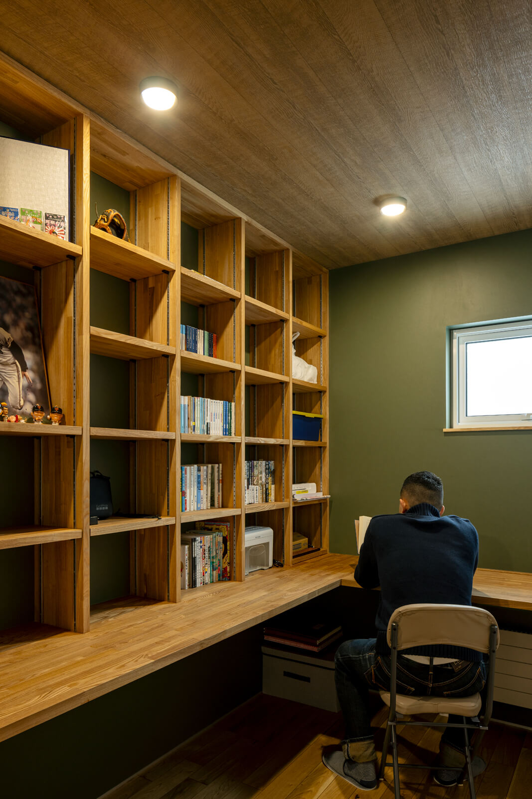 蔵書の多いTさんの要望で、2階に設えた書斎。オーク材の造作本棚とカウンターテーブルを備えた室内は、工藤代表の提案で抹茶色のクロスを採用