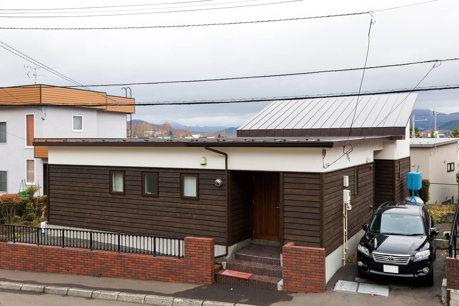 既存の建物を生かして2階部分を減築。北海道産のスギ板と漆喰で仕上げたシンプルなフォルムの住まい