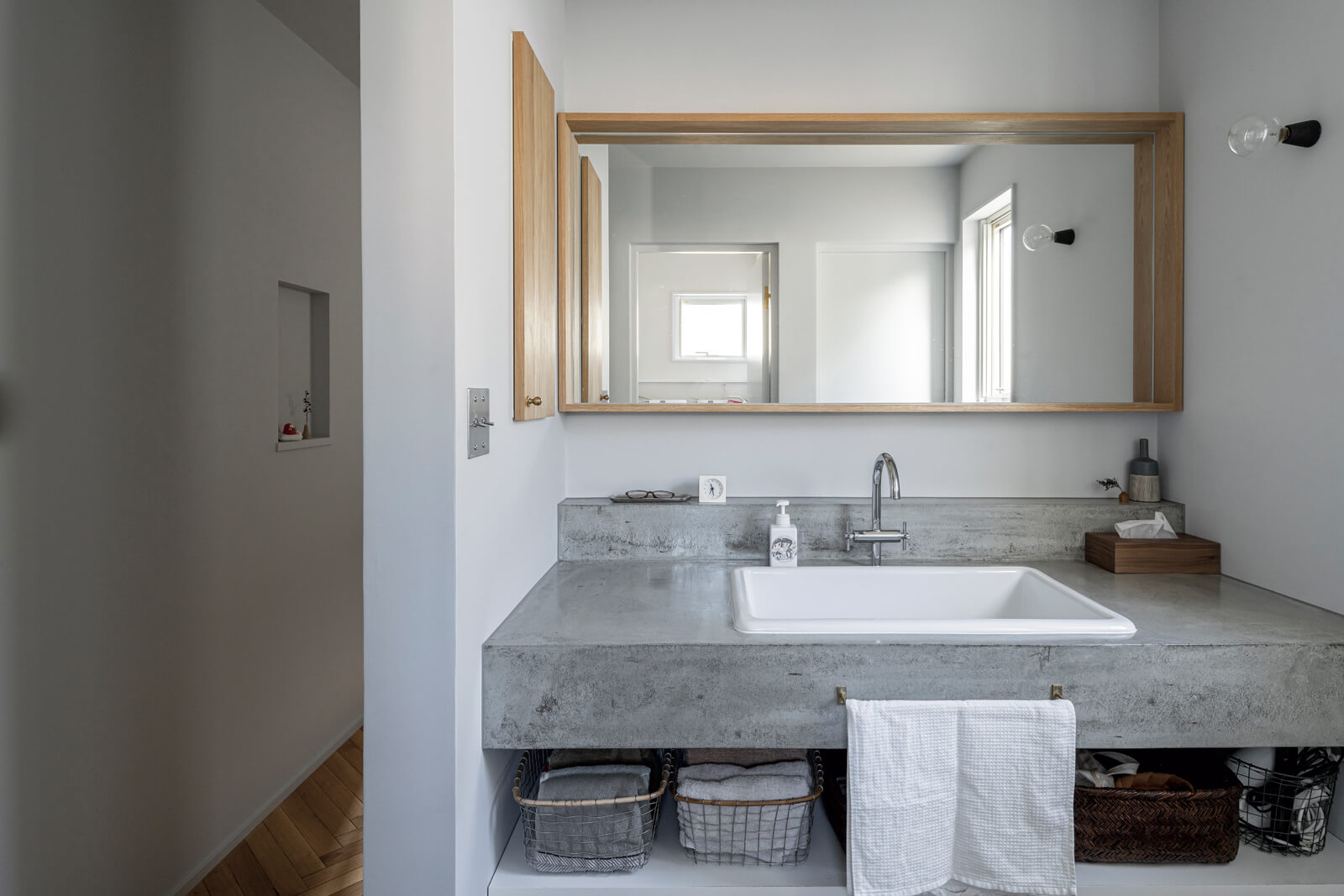 モルタル仕上げの造作洗面台は、帰宅後すぐに手洗いがしやすいよう、玄関から直行できる位置に配置されている