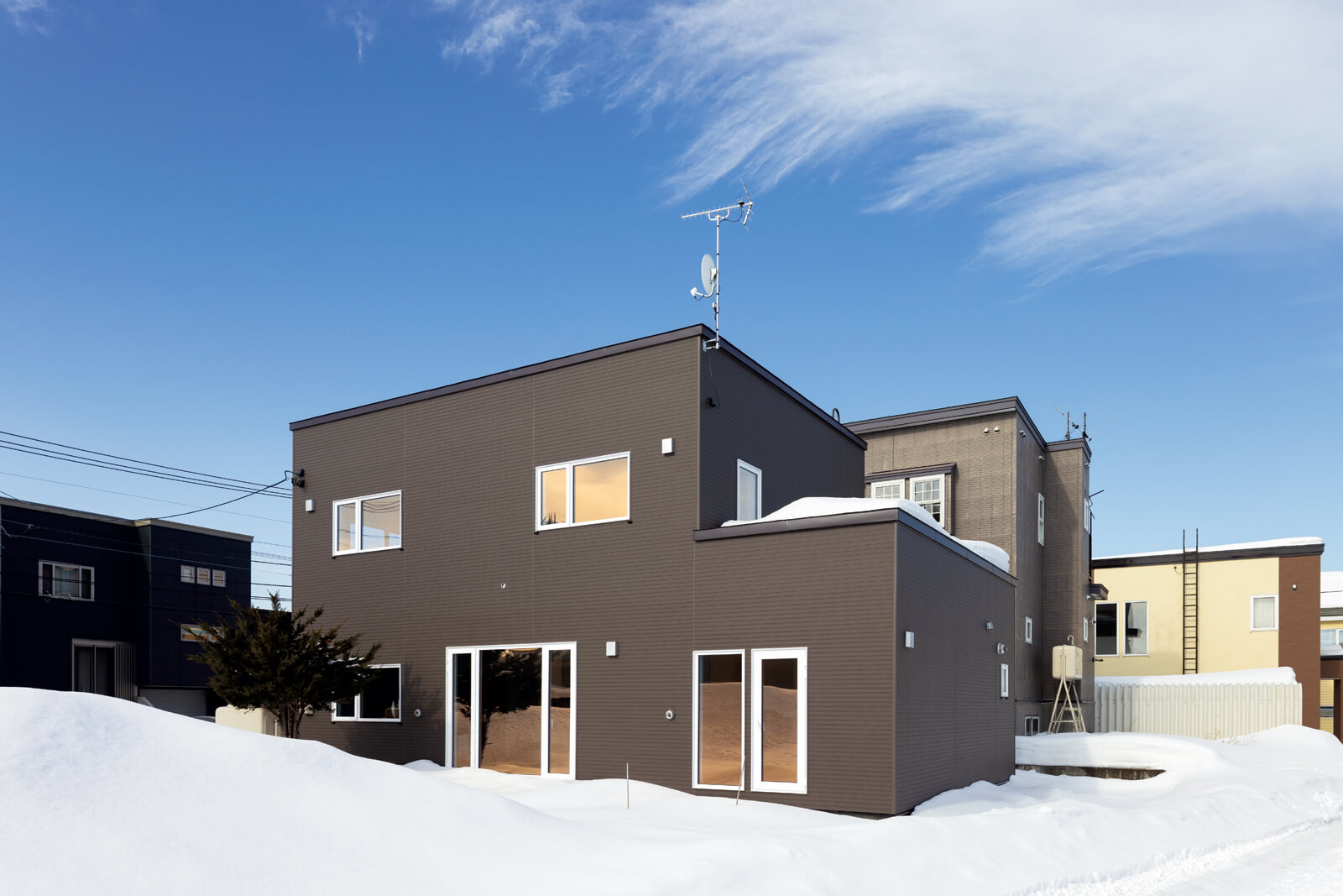 傾斜の強い大屋根を無落雪屋根に改修したことで、スクエアなフォルムに替わった外観。外壁は窯業系サイディングで仕上げた