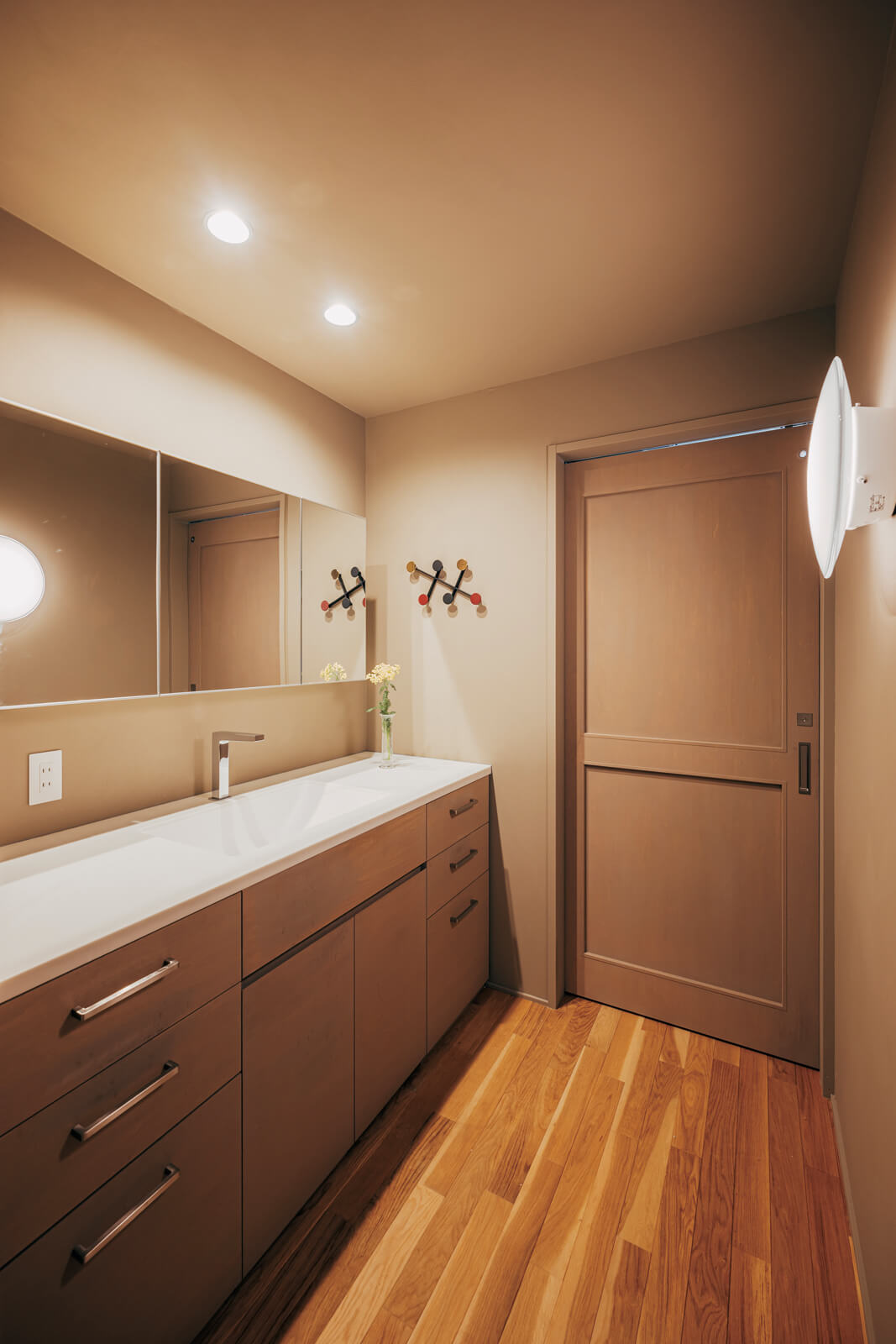 洗面室はカウンター下や鏡に収納をまとめ、シンプルな設えにしている