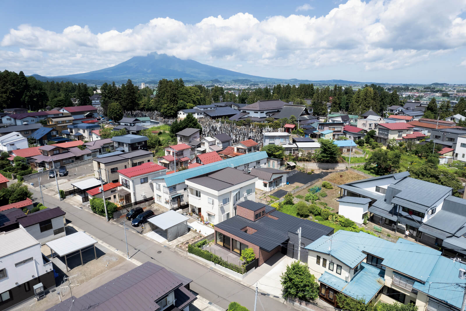 穏やかな住宅街に立つ小さな庭のある平屋