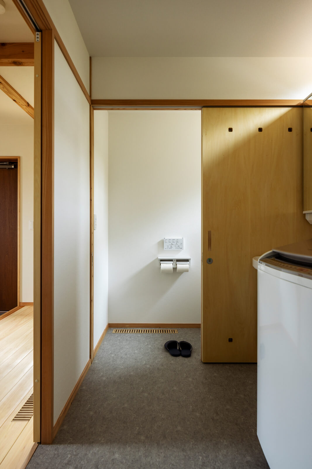 LDKに隣接して、水まわりとトイレを集約。洗面脱衣は洗濯室も兼ねる。トイレの引き戸は造作