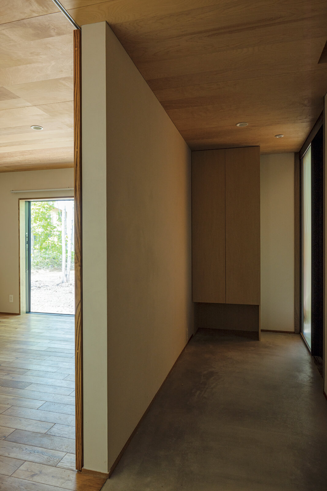 段差のない土間づくりの玄関は、そのまま居住空間につながる。壁を挟んで左手は訪れるゲストのために用意した個室