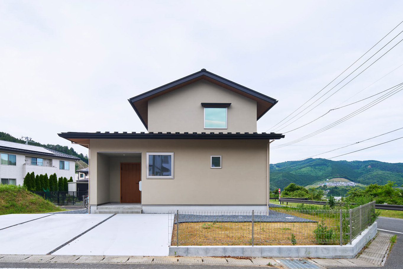 南側からの外観。シンプルながらもベージュ色の塗り壁が温かな風合いを醸し出す