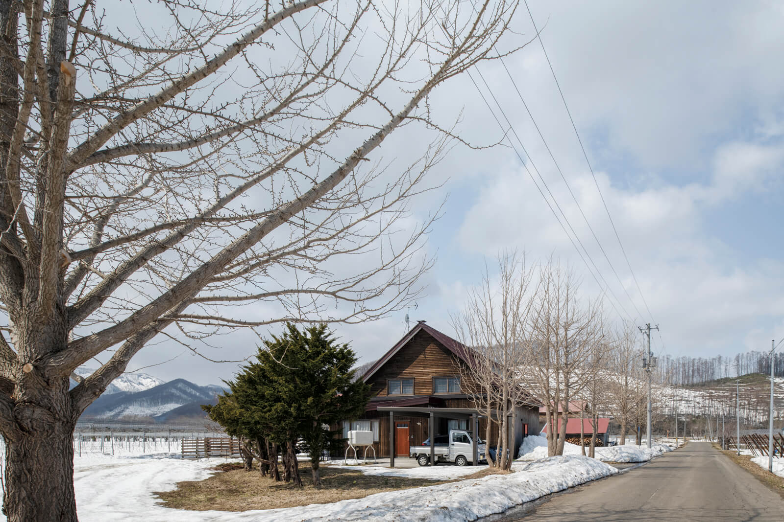 果樹園が広がる地域の一角に立つSさんの家。春は一面の緑に、秋には豊かな実りと色鮮やかな紅葉に包まれる