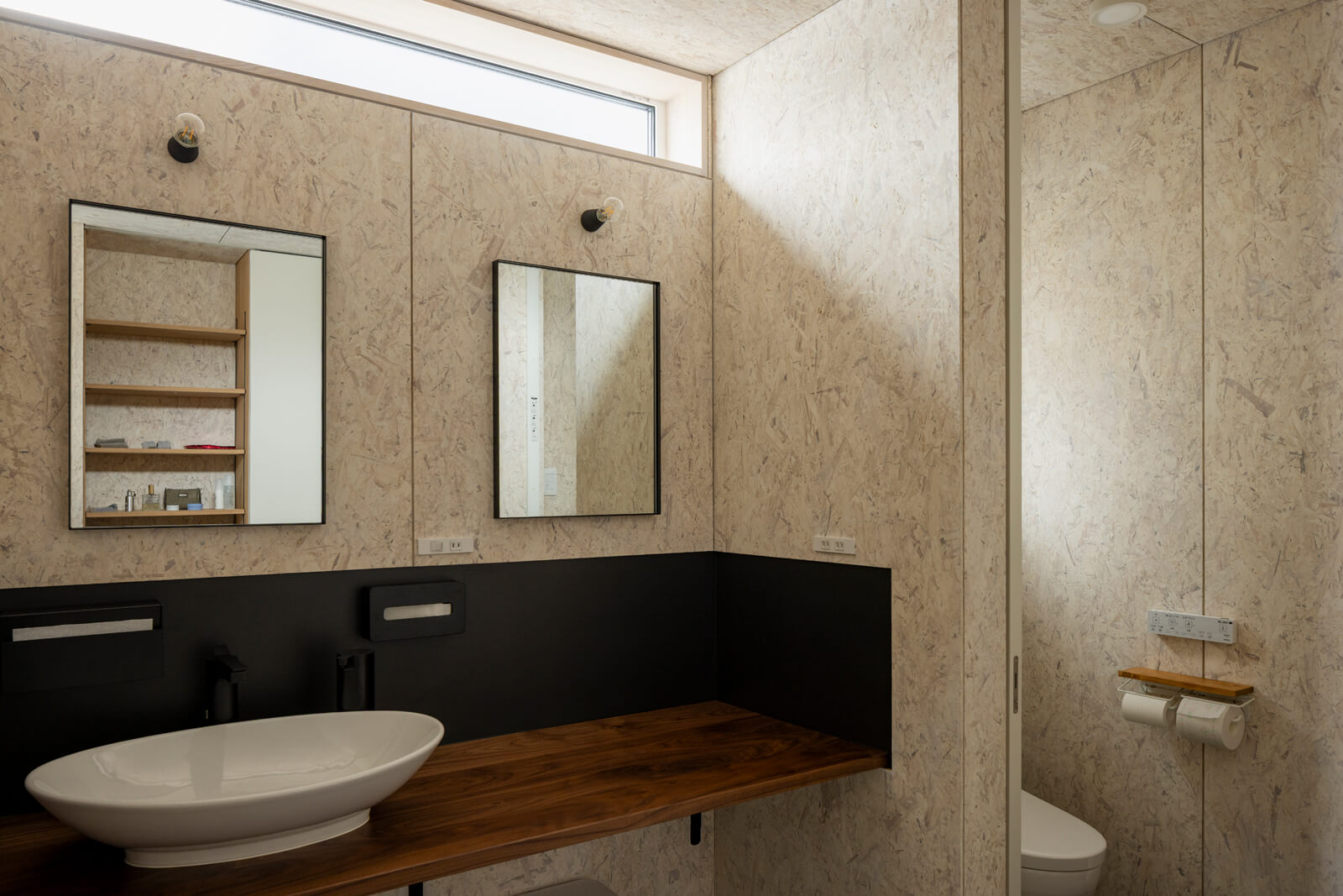 壁面のバックガードにガルバリウム鋼板を採用し、掃除のしやすさを念頭に洗面ボウルや水栓も吟味したAさんお気に入りの造作洗面台。隣にはトイレを配置