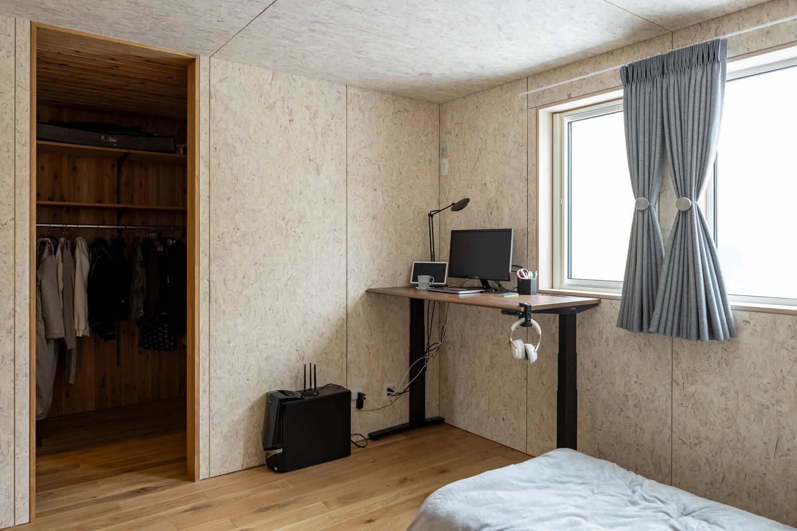 寝室の壁材と天井材も、LDKまわりと同じOSB。Aさんの要望で廻り縁や幅木を一切付けずにすっきりと仕上げた