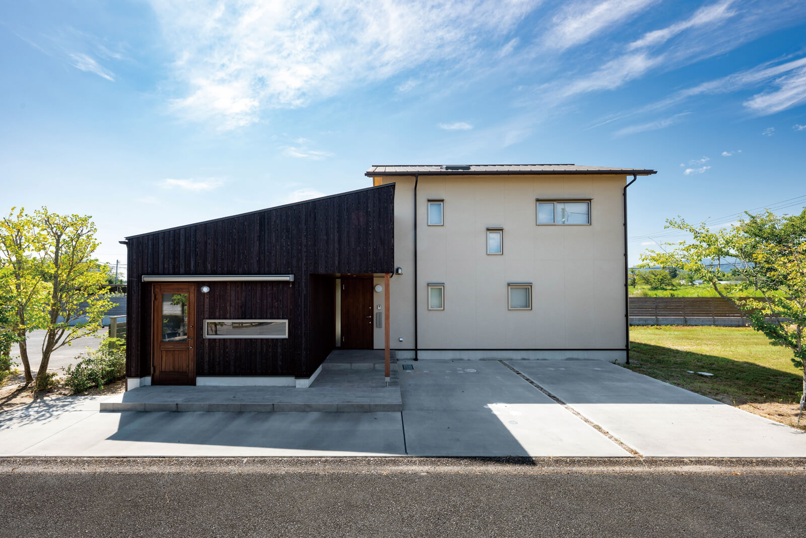 左のアトリエに対して、住居部分は少し下がる形に配置。アトリエ右端のポーチ奥に玄関がある