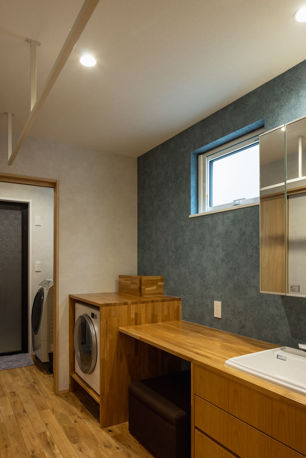 玄関からつながるユーティリティ。1ヵ所で洗う・干す・畳むが完結することで家事の効率化を図る。造作の作業台は奥さんが身支度をするのにも使える