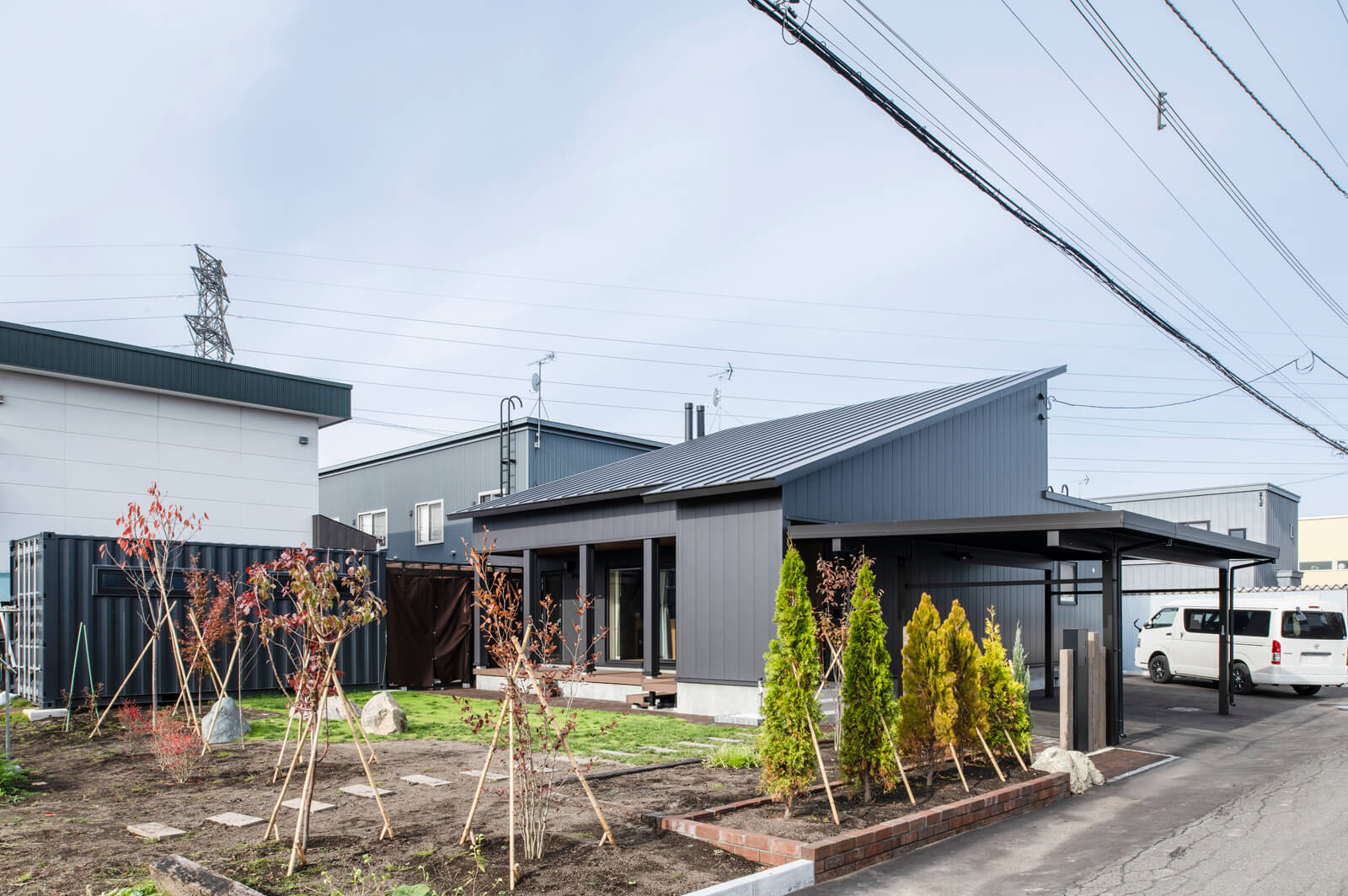 広々とした庭には、桜やベリーなど、季節の変化が楽しめる樹種を選んで植えた。写真左奥に見える窓付きのコンテナは、半分は畑仕事用の道具置き場、もう半分には電気式サウナを設置して、家での暮らしを楽しんでいる