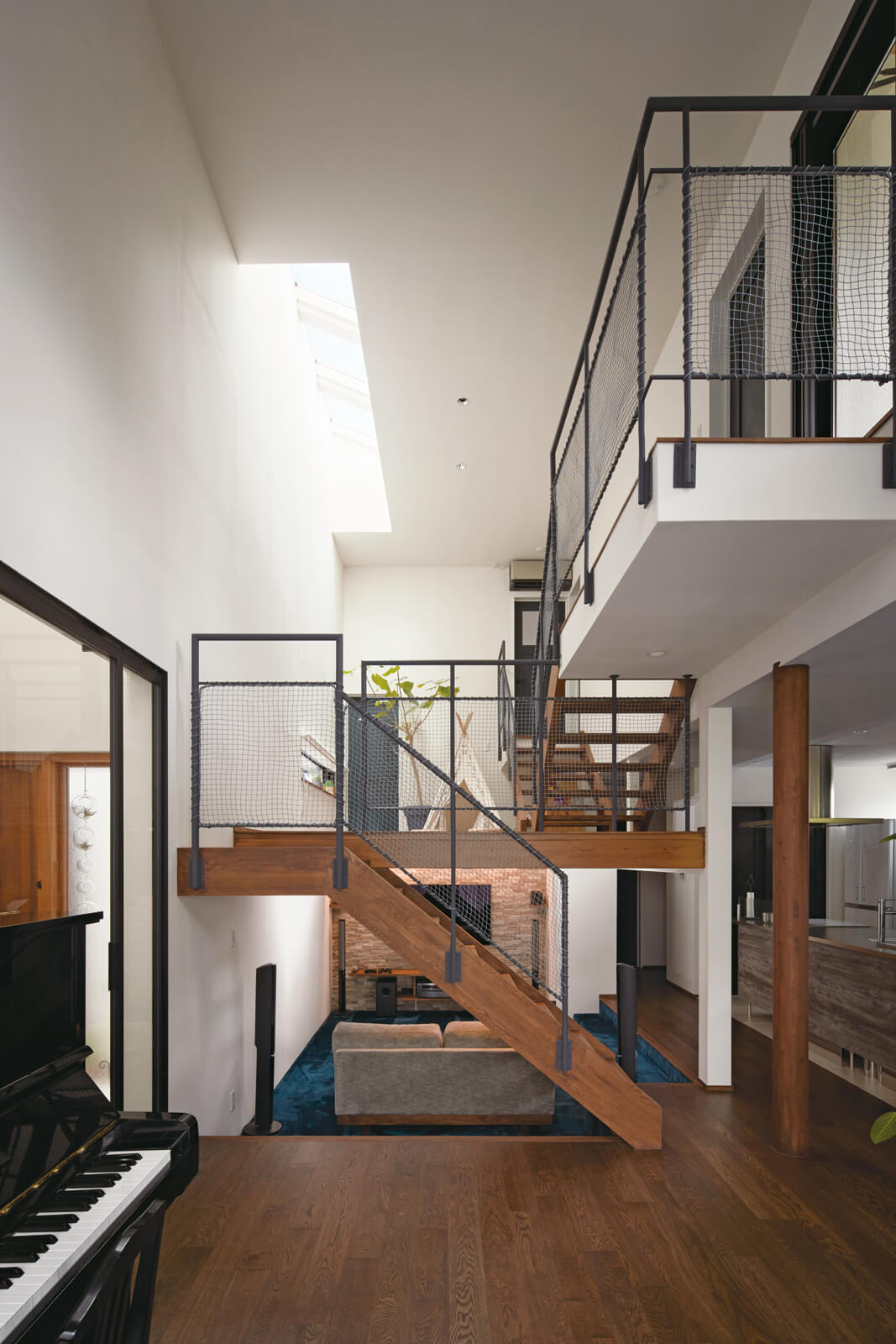 大きな吹き抜け空間に4つの床レベルが複雑に入り組み、多様な陰影や躍動感を生み出している子世帯