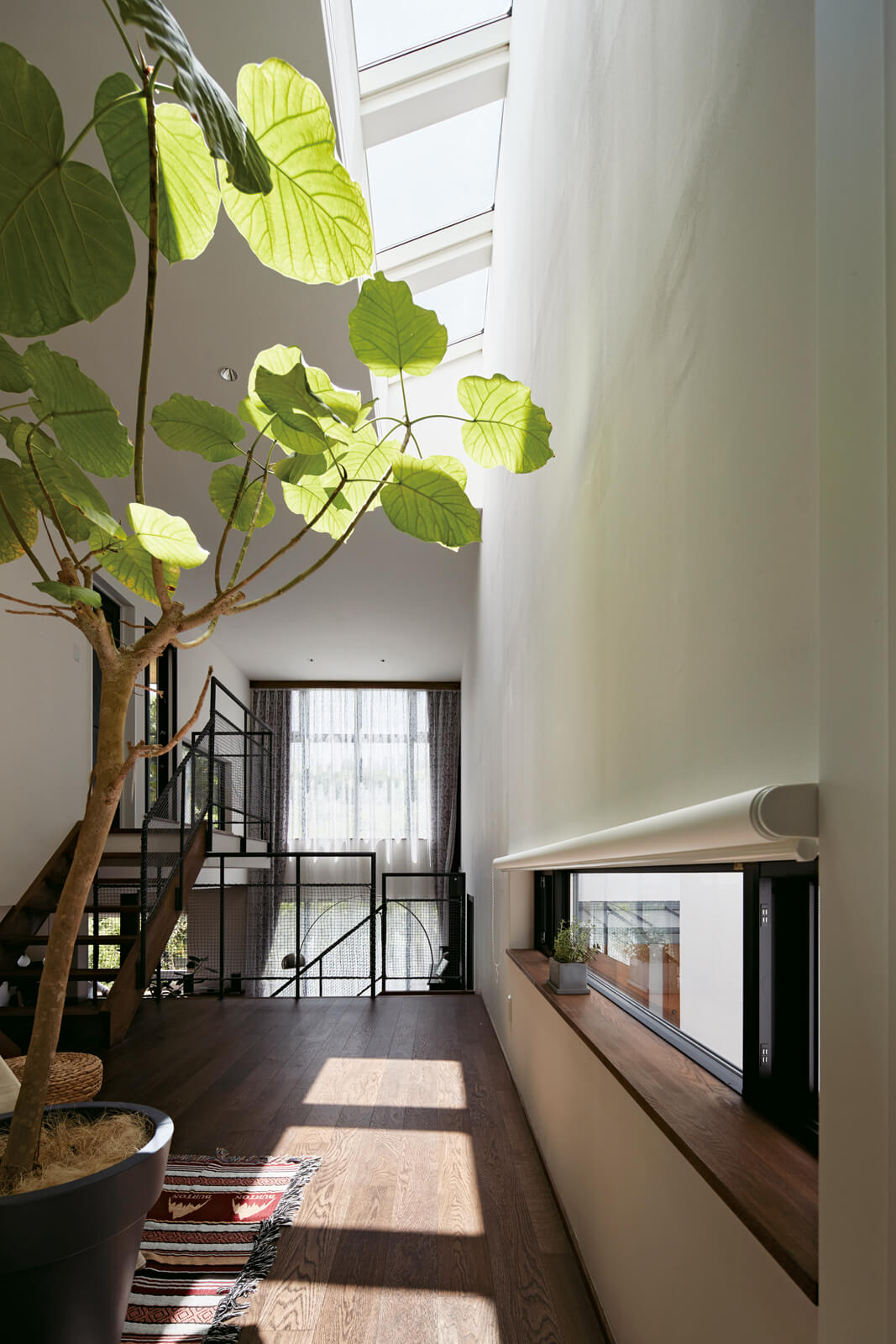 小学生と幼児、2人のお子さんの格好の遊び場となっている中2階の広間。トップライトからの自然光が心地よい空間だ