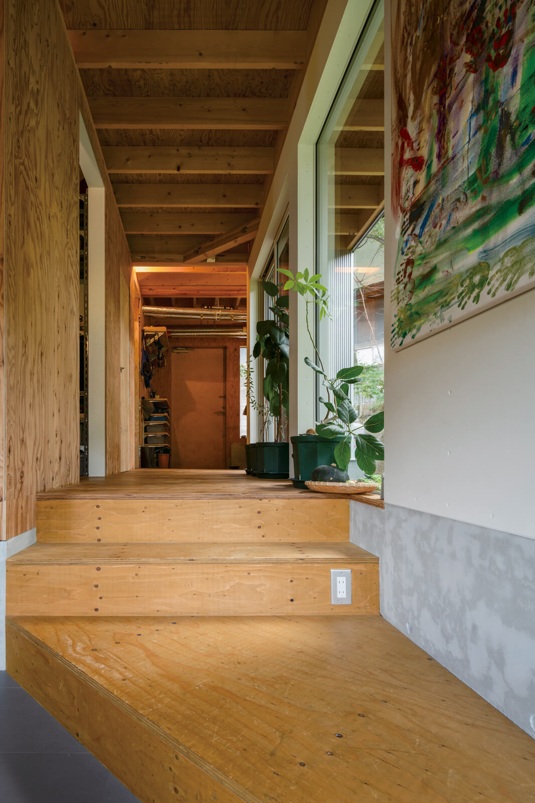 玄関から玄関ホール、テラスまでは基礎の天端の高さで、ダイニングへ向かうステップを下りると凍結深度の深さに床レベルが下がる。壁の石膏ボードの下のコンクリートが基礎部分