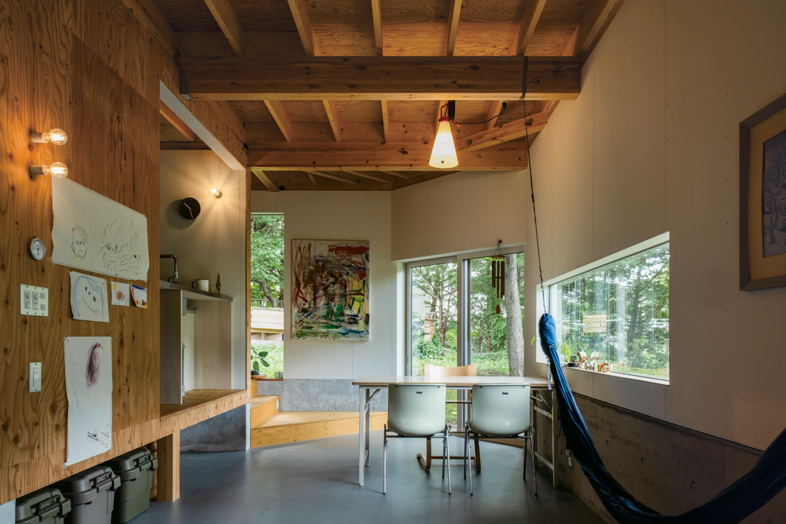 Kさん宅は仕切りを持たない。ダウンフロアで天井高を感じる開放的なダイニングスペース。食事の際はステージのようなキッチンから、直接手渡しで配膳する