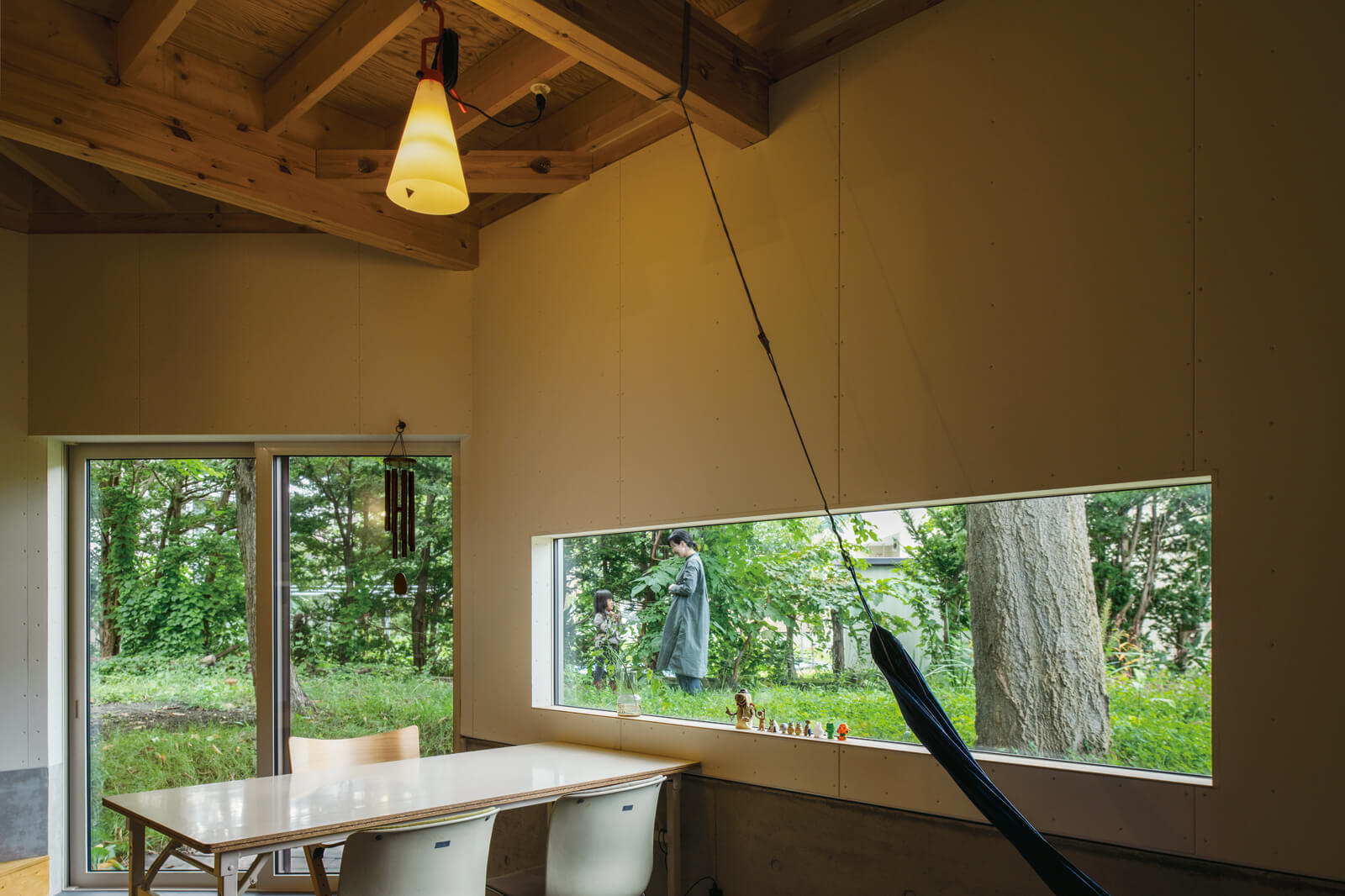 Kさん宅は仕切りを持たない。ダウンフロアで天井高を感じる開放的なダイニングスペース。食事の際はステージのようなキッチンから、直接手渡しで配膳する