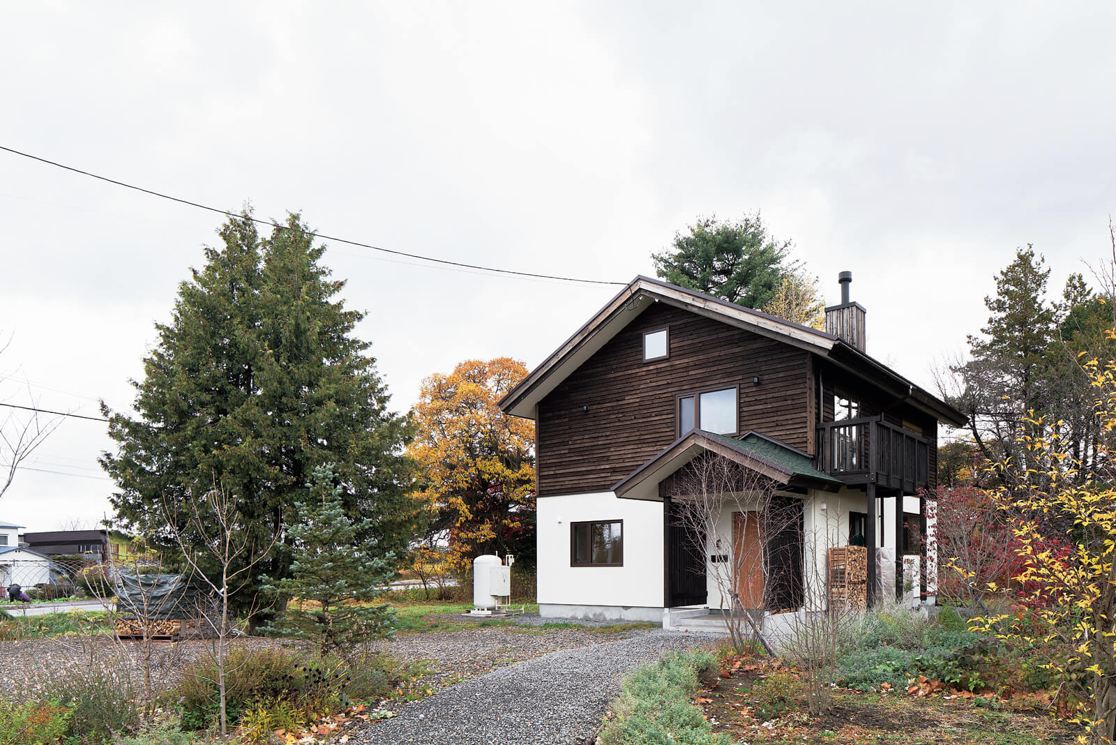 道路から玄関までは砂利を敷き詰めたアプローチに。夏には美しい花々が小道を彩ってくれる