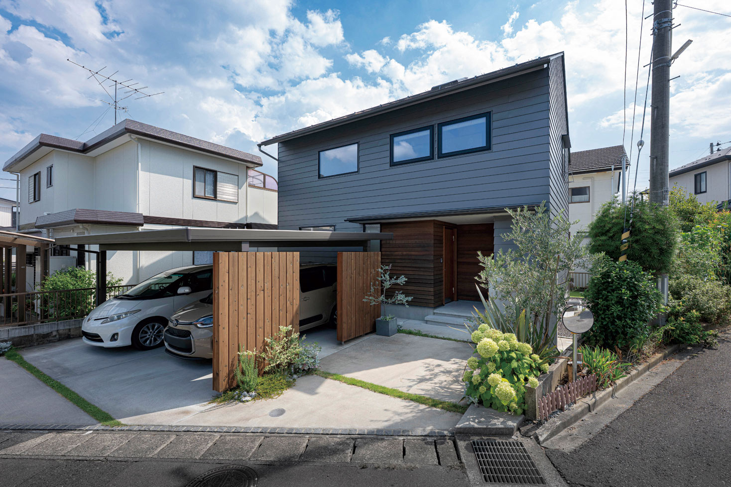 グレーのガルバリウム鋼板の外壁材がシックな印象を与えるFさんの住まい。ご主人の希望で建物の前にカーポートを設けたことで、冬場の除雪や除霜の負担がなくなり、出勤時のストレスが減ったそう。カーポートの玄関側には板塀を組み合わせて、建物と一体感を持たせた