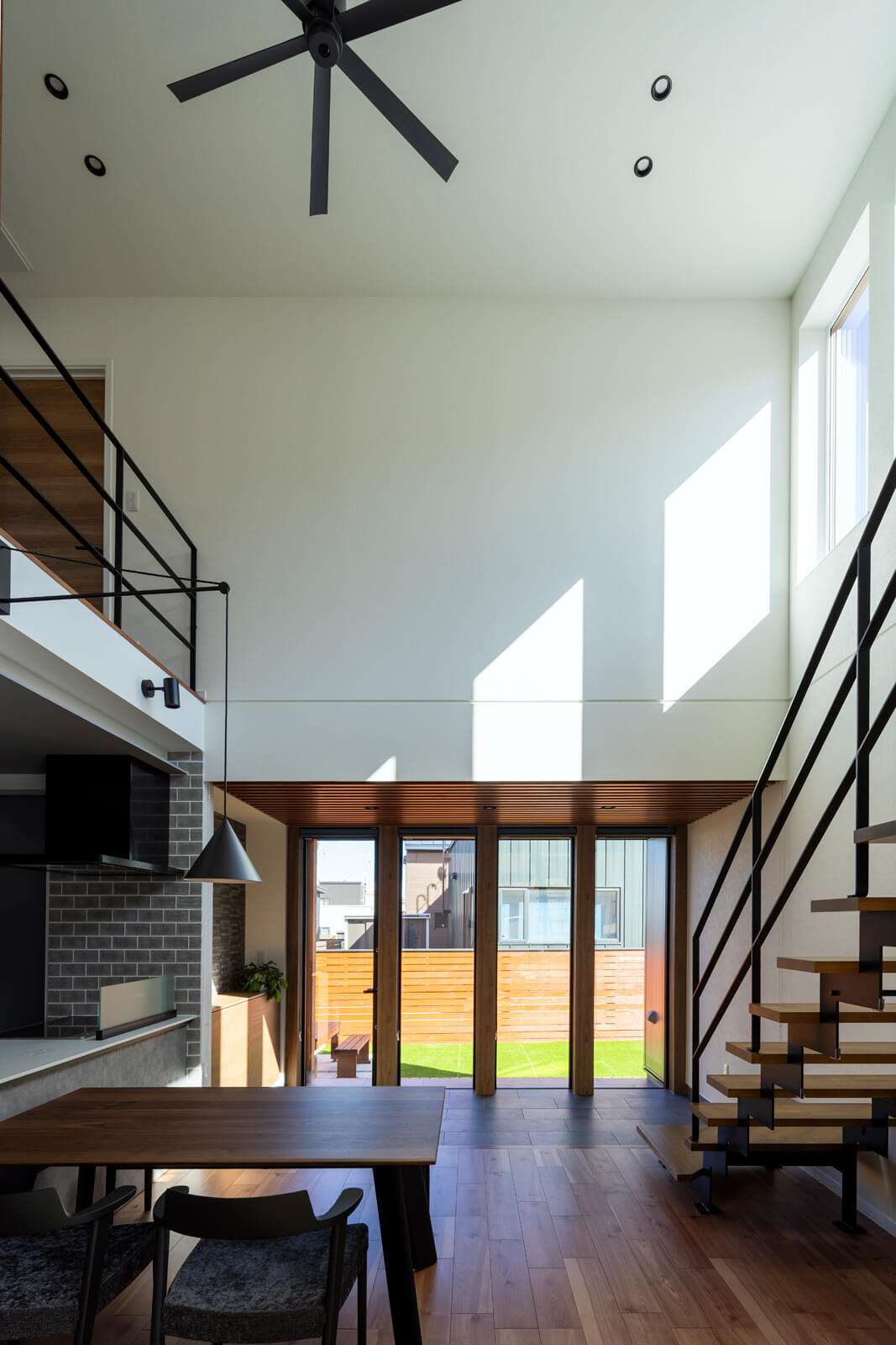 高さ5m超の吹き抜けに設えたハイサイドライトから、ダイニング空間に自然光がたっぷり降り注ぐ。ガラス越しに見える空の移ろいも美しい