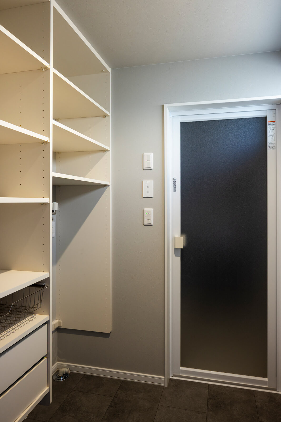 壁一面に収納を造作した洗濯脱衣室。ボイラーや洗面台の配置を工夫したことで、ゆったりとした空間に仕上がった