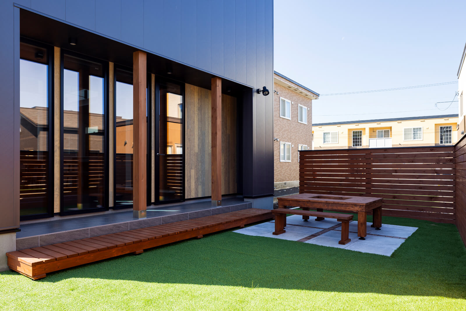 裏庭はドッグランやバーベキュースペース、ガーデニングなど、屋外の多目的空間として利用できるよう、木製の柵と人工芝、コンクリート平板で整えた